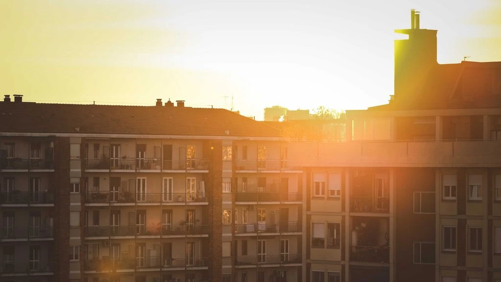Une femme lit près d'une fenêtre parisienne baignée de lumière dorée